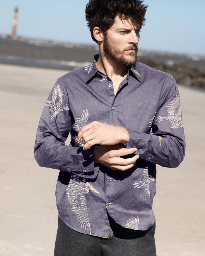 Model wears the pelican swarm wilson shirt on the beach of Charleston.