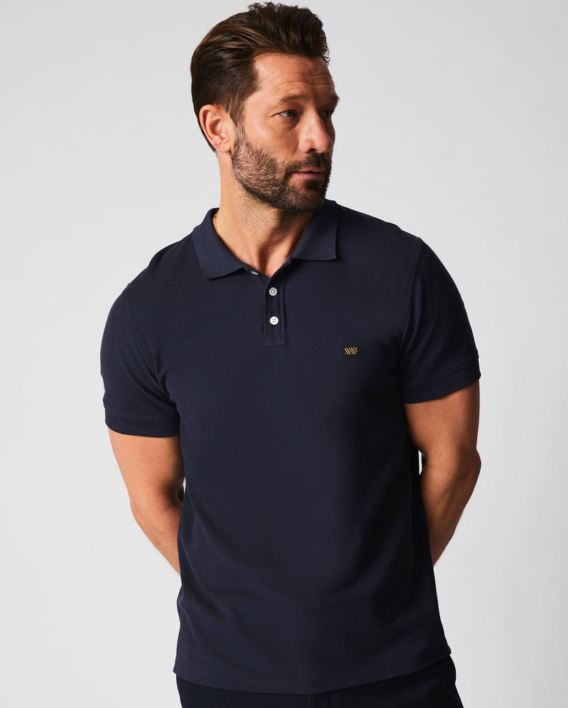 Male model wears the Pique Polo in Navy